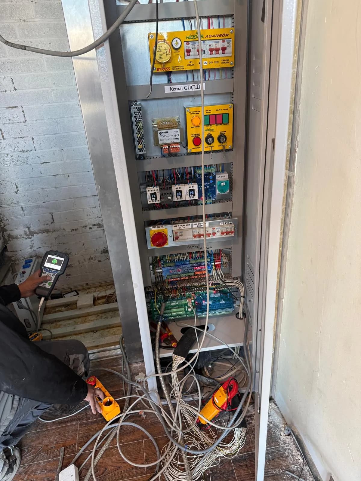New lift control panel being commissioned with diagnostic equipment