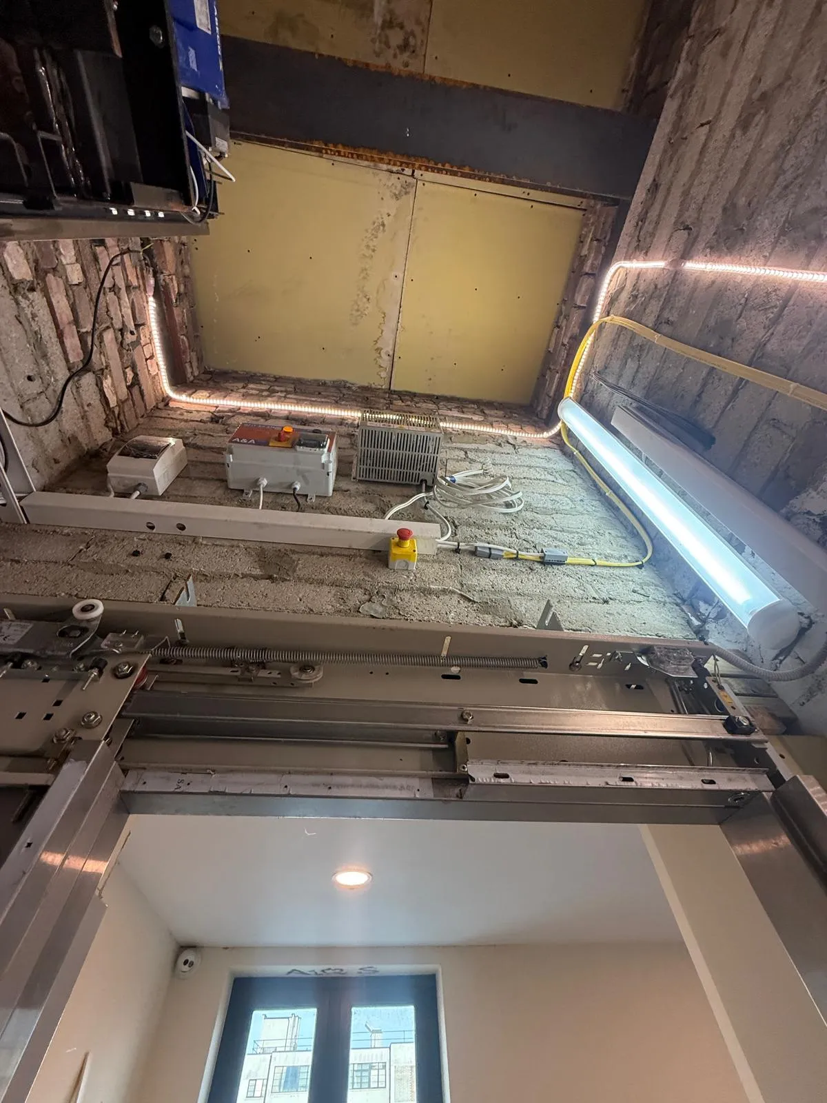 View up the lift shaft showing new door equipment and LED shaft lighting